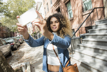 Mixed Race woman in city posing for cell phone selfie - BLEF02396