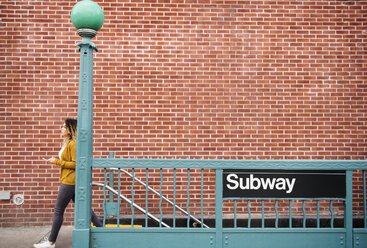 Gemischtrassige Frau beim Verlassen einer U-Bahn-Station in der Stadt - BLEF02407