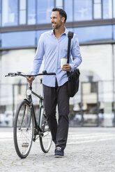 Businessman with bicycle on the go in the city - DIGF06964