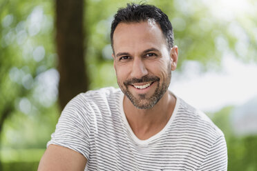 Portrait of smiling man in a park - DIGF06998