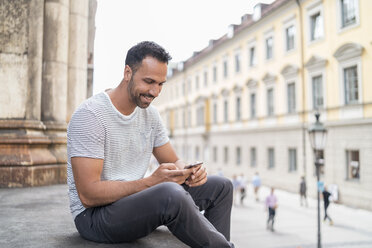 Lächelnder Mann beim Telefonieren in der Stadt - DIGF07009