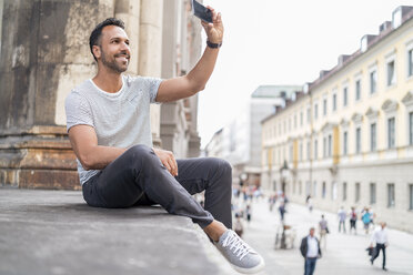 Ein lächelnder Mann macht ein Selfie in der Stadt - DIGF07011