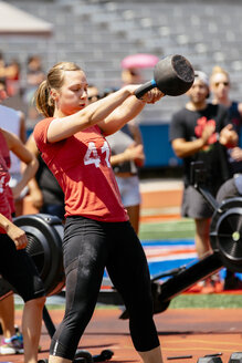 Frau hebt Kettlebell im Freien - BLEF02505