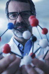 Hispanic scientist examining molecule model - BLEF02568