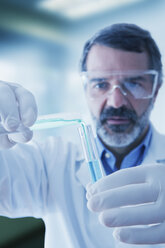 Hispanic researcher mixing vials of liquid - BLEF02572