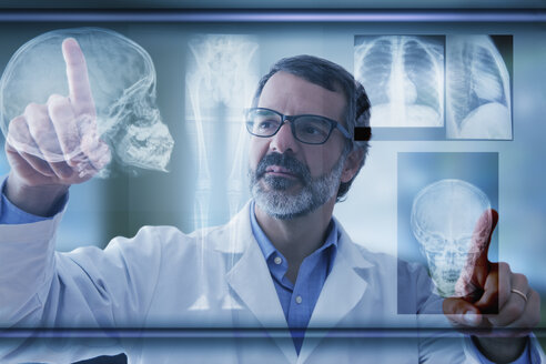 Hispanic doctor examining x-rays on virtual screen - BLEF02575