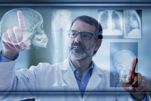 Hispanischer Arzt, der Röntgenbilder auf einem virtuellen Bildschirm untersucht - BLEF02575