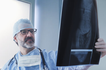 Hispanischer Chirurg bei der Untersuchung von Röntgenbildern - BLEF02578