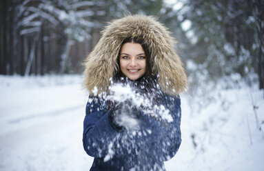 Portrait of playful Caucasian woman throwing snow - BLEF02600