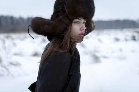 Ernste kaukasische Frau mit Pelzmütze und Mantel im Winter, lizenzfreies Stockfoto