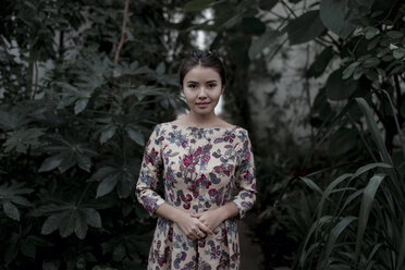 Asian woman smiling near foliage - BLEF02619