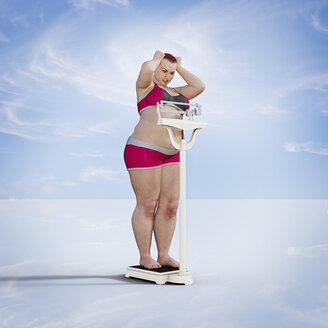 Frustrated woman checking weight on scale - BLEF02627