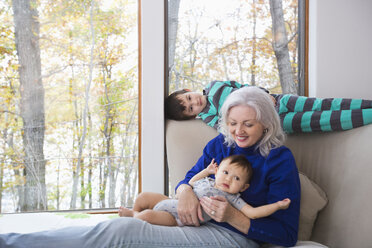 Smiling grandmother and grandsons near window - BLEF02689
