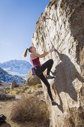 Kaukasisches Teenager-Mädchen klettert auf Felsen - BLEF02728
