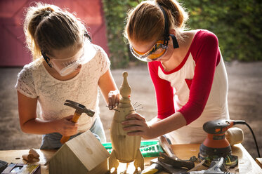 Sisters building birdhouse in garage - BLEF02773