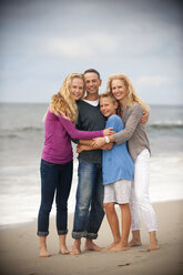 Portrait of smiling family hugging on beach - BLEF02806