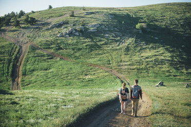 Caucasian couple walking on path toward hill - BLEF02834
