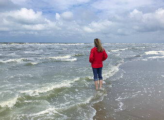 Belgien, Flandern, Nordsee, Frau steht barfuß in den Wellen des Meeres und entspannt sich - GWF06071