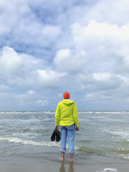 Belgien, Flandern, Nordsee, Mann steht barfuß in den Wellen, entspannt sich und beobachtet die Wellen, lauscht dem Meeresrauschen - GWF06073
