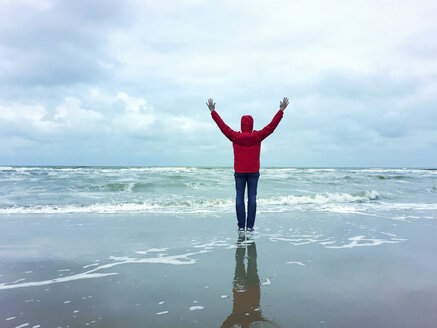 Belgien, Flandern, Nordsee, Frau steht am Strand, entspannt, genießt die Freiheit und das Meer - GWF06074