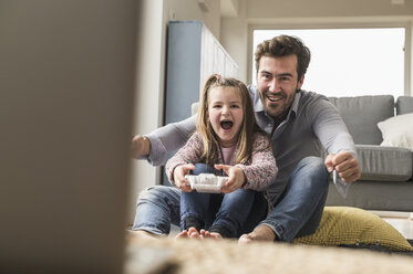 Young man and little girl playing computer game with gaming console - UUF17338