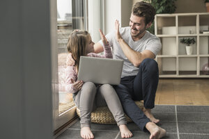 Young man and little girl surfing the net together - UUF17353