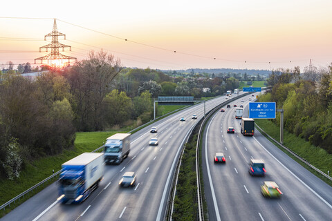 Deutschland, Baden-Württemberg, Verkehr auf der Autobahn A8 bei Sonnenuntergang, lizenzfreies Stockfoto