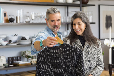Mann zeigt Frau im Geschäft Pullover - BLEF02906