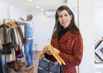 Frau beim Einkaufen von Jeans in einem Bekleidungsgeschäft - BLEF02914