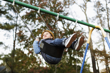 Mixed Race boy on playground swing - BLEF02948