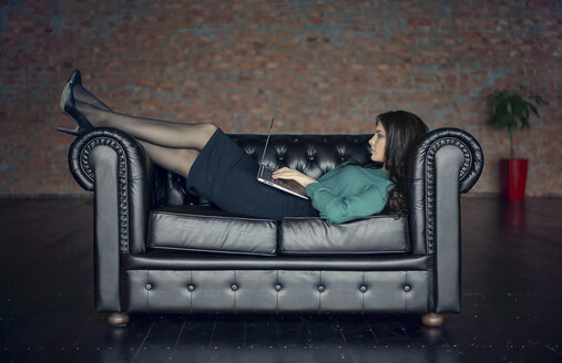 Kaukasische Geschäftsfrau auf dem Sofa liegend mit digitalem Tablet - BLEF02967
