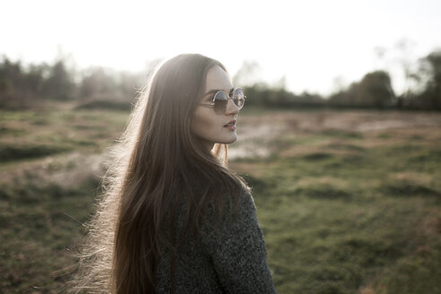 Kaukasische Frau mit Sonnenbrille auf einem Feld - BLEF02975