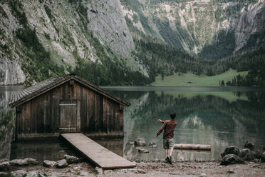 Kaukasischer Mann, der Steine in einem Bergsee springt - BLEF02989