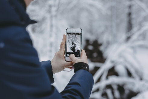 Kaukasische Frau fotografiert Schnee mit Handy - BLEF02992