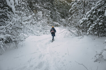 Kaukasische Frau beim Wandern im verschneiten Wald - BLEF02994