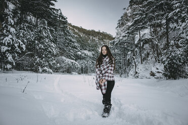 Caucasian woman wrapped in blanket in snowy forest - BLEF02998