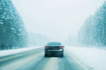 Autofahrt auf einer von Bäumen gesäumten Straße im Winter - BLEF03042