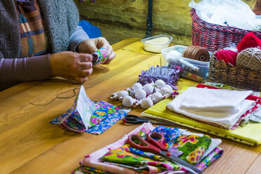 Woman sewing fabric at table - BLEF03044