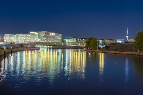 Deutschland, Berlin, Blick auf beleuchtete moderne Gebäude nahe der Spree - TAMF01387