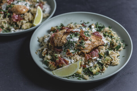 Cajun-Hähnchen mit Speck, Zucchini-Zitronen-Reis und Joghurtsauce, lizenzfreies Stockfoto