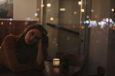 Portrait of young woman behind windowpane in a restaurant - KNSF05756