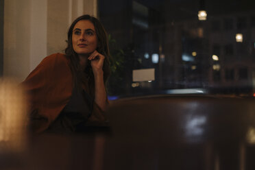 Portrait of smiling young woman sitting at table in a restaurant - KNSF05758