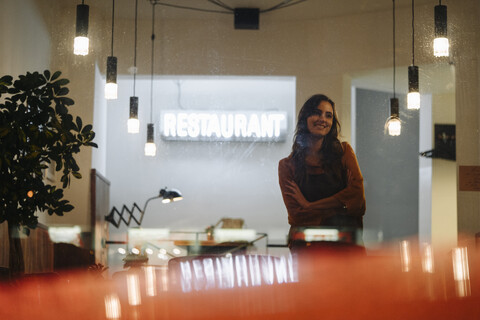 Smiling woman wearing apron standing in a restaurant stock photo