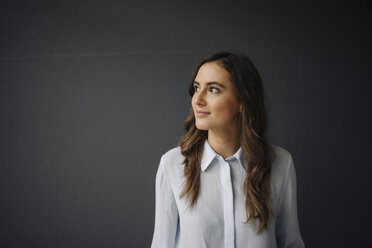 Portrait of smiling young businesswoman looking sideways - KNSF05774