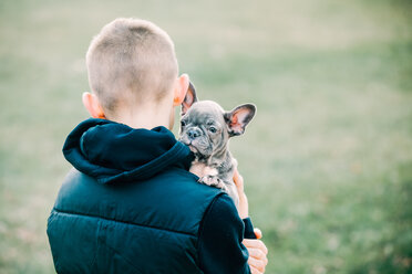 Boy carrying puppy outdoors - ISF21249