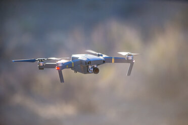 Drone (unmanned aerial vehicle) flying mid air, shallow focus - ISF21251