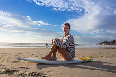 Weibliche Surferin auf dem Surfbrett sitzend am Strand, Porträt, Kapstadt, Westkap, Südafrika - ISF21269