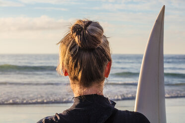 Weibliche Surferin mit Surfbrett am Strand, Kopf- und Schulteransicht von hinten, Kapstadt, Westkap, Südafrika - ISF21271