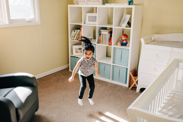 Mädchen springt mitten in der Luft im Kinderzimmer, Porträt - ISF21274