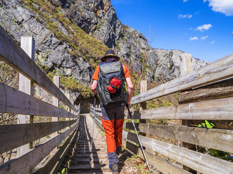 Spanien, Asturien, Kantabrisches Gebirge, älterer Mann auf Wanderschaft beim Überqueren einer Brücke - LAF02308